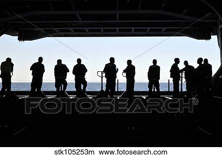 Picture - Silhouette of sailors standing in the hangar bay aboard USS Carl Vinson.. Fotosearch