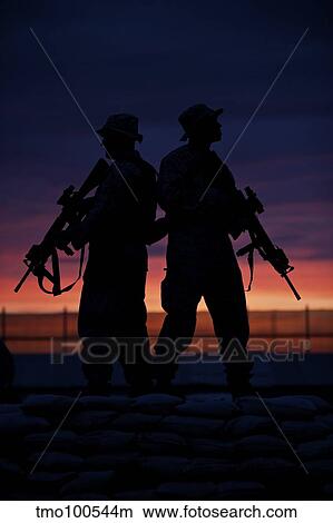 Picture - Silhouette of U. S Marines on a bunker at sunset in Afghanistan.. Fotosearch