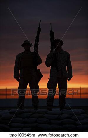 Picture - Silhouette of U. S Marines on a bunker at sunset in Afghanistan.. Fotosearch