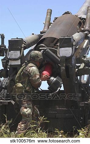 Soldier loads a charge round behind the ammunition round of the Howitzer 150 gun. View Large Photo Image Picture - Soldier loads a charge round behind the ammunition round of the Howitzer 150 gun.. Fotosearch
