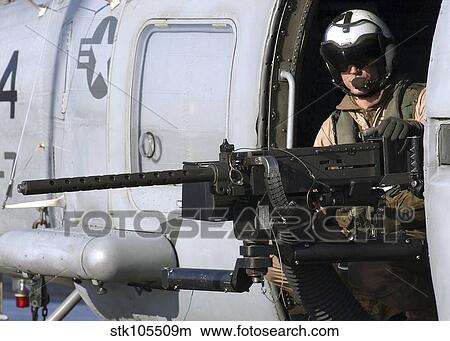 Soldier mans a. 50 caliber machine gun on an SH-60 Seahawk. View Large Photo Image Picture - Soldier mans a. 50 caliber machine gun on an SH-60 Seahawk.. Fotosearch