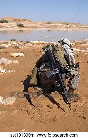Soldier patrols along a riverbed on a search and rescue mission. View Large Photo Image Picture - Soldier patrols along a riverbed on a search and rescue mission.. Fotosearch