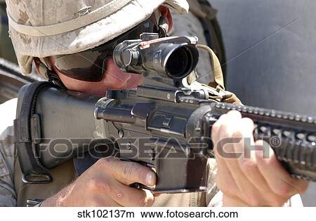 Picture - Soldier peers through his sights as he maintains security.. Fotosearch