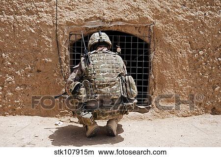 Picture - Soldier searches a compound in Afghanistan.. Fotosearch