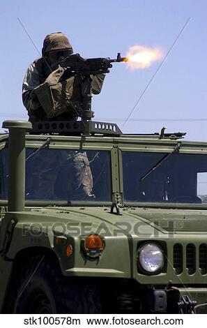 Soldier shoots a M-240B machine gun atop a humvee. View Large Photo Image Picture - Soldier shoots a M-240B machine gun atop a humvee.. Fotosearch