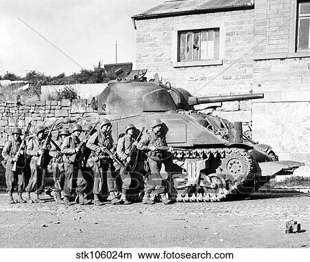 Soldiers and their tank advance into a Belgian town during WWII. View Large Photo Image Picture - Soldiers and their tank advance into a Belgian town during WWII.. Fotosearch