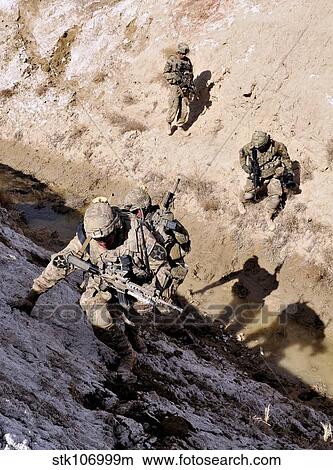 Soldiers approach a suspected weapons cache in Afghanistan. View Large Photo Image Picture - Soldiers approach a suspected weapons cache in Afghanistan.. Fotosearch
