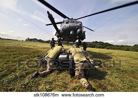 Soldiers mount an inflatable Zodiac boat to the bottom of a HH-60 Pave Hawk. View Large Photo Image Picture - Soldiers mount an inflatable Zodiac boat to the bottom of a HH-60 Pave Hawk.. Fotosearch