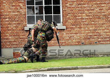 Soldiers of the Belgian Army helping and transporting a wounded mate. View Large Photo Image Picture - Soldiers of the Belgian Army helping and transporting a wounded mate.. Fotosearch