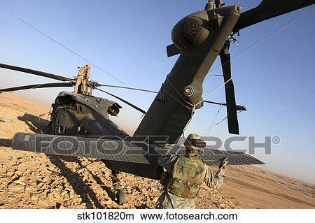 Soldiers prepare a UH-60 Black Hawk helicopter for transport. View Large Photo Image Picture - Soldiers prepare a UH-60 Black Hawk helicopter for transport.. Fotosearch