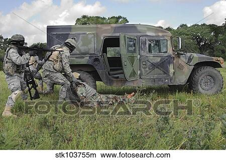 Picture - Soldiers recover the victim of a simulated roadside bomb. Fotosearch