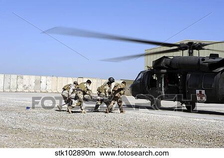 Soldiers rush a simulated casualty to a UH-60 Blackhawk helicopter. View Large Photo Image Picture - Soldiers rush a simulated casualty to a UH-60 Blackhawk helicopter.. Fotosearch