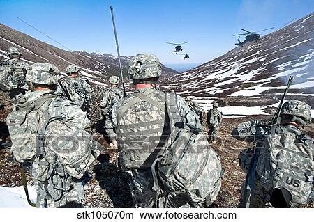 Soldiers wait for UH-60 Black Hawk helicopters to land in Alaska's Chugach Range. View Large Photo Image Picture - Soldiers wait for UH-60 Black Hawk helicopters to land in Alaska's Chugach Range.. Fotosearch