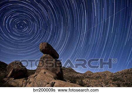 Stock Photograph - Star trails above a granite rock formation in Cleveland National Forest, California.. Fotosearch