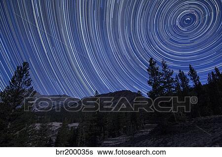 Stock Photograph - Star trails above mountain peaks near Yosemite National Park, California.. Fotosearch