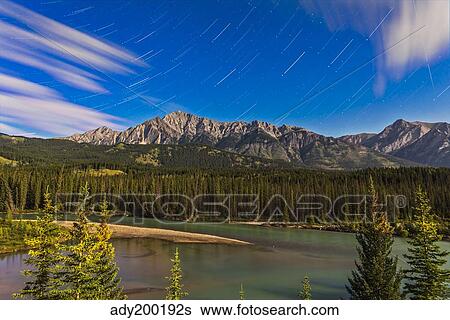 Stock Photograph - Star trails above the Front Ranges in Banff National Park, Alberta, Canada.. Fotosearch