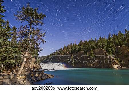 Star trails and moonbow over Bow Falls on the Bow River in Banff, Alberta, Canada. View Large Photo Image Stock Photograph - Star trails and moonbow over Bow Falls on the Bow River in Banff, Alberta, Canada.. Fotosearch