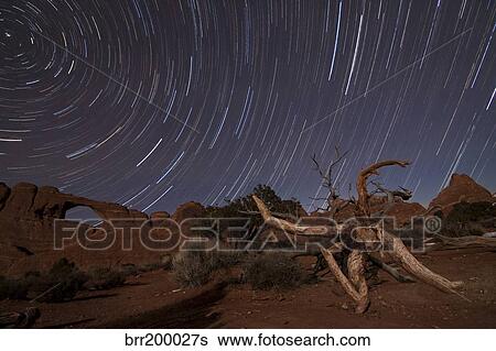 Stock Photograph - Star trails over Skyline Arch at Arches National Park, Utah.. Fotosearch