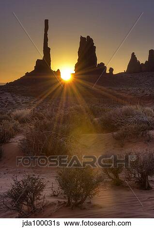 Sunburst through the Totem Pole formation in Monument Valley, Utah. View Large Photo Image Stock Photograph - Sunburst through the Totem Pole formation in Monument Valley, Utah.. Fotosearch