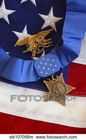 The Medal of Honor rests on a flag beside a SEAL trident. View Large Photo Image Picture - The Medal of Honor rests on a flag beside a SEAL trident.. Fotosearch