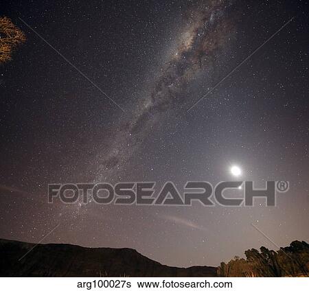 Stock Photograph - The Milky Way, the Moon and Venus over the fields in Azul, Argentina.. Fotosearch