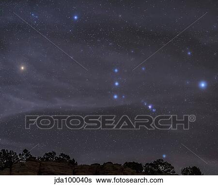 The Orion constellation rises over a hill through high thin clouds. View Large Photo Image Stock Photograph - The Orion constellation rises over a hill through high thin clouds.. Fotosearch