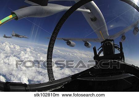 The refueling boom from a KC-135 Stratotanker arches over an F-15 Eagle as it refuels the aircraft. View Large Photo Image Picture - The refueling boom from a KC-135 Stratotanker arches over an F-15 Eagle as it refuels the aircraft.. Fotosearch