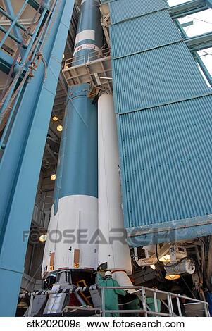Stock Photograph - The second solid rocket motor is moved into place alongside the Delta II first stage.. Fotosearch