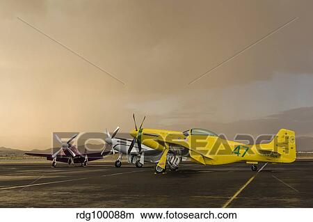 Three P-51 Mustangs parked on the ramp ahead of a storm. View Large Photo Image Picture - Three P-51 Mustangs parked on the ramp ahead of a storm.. Fotosearch