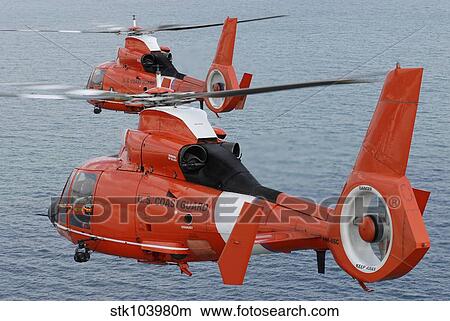 Two Coast Guard HH-65C Dolphin helicopters fly in formation over the Atlantic Ocean. View Large Photo Image Picture - Two Coast Guard HH-65C Dolphin helicopters fly in formation over the Atlantic Ocean.. Fotosearch