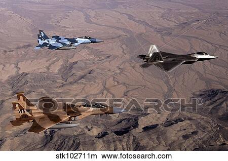 Two F-15 Agressor Eagles fly in formation with a F-22 Raptor. View Large Photo Image Picture - Two F-15 Agressor Eagles fly in formation with a F-22 Raptor.. Fotosearch