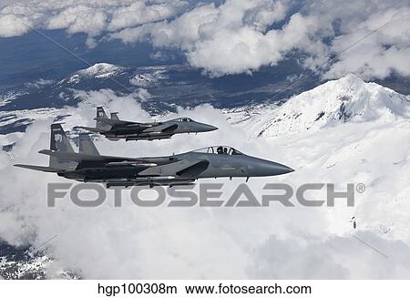 Two F-15 Eagles fly past snow capped peaks in Central Oregon. View Large Photo Image Picture - Two F-15 Eagles fly past snow capped peaks in Central Oregon.. Fotosearch