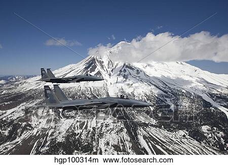 Picture - Two F-15 Eagles fly past snow capped peaks in Central Oregon.. Fotosearch