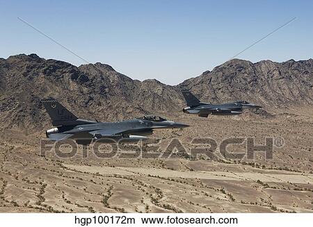 Two F-16's fly in formation over the Arizona desert. View Large Photo Image Picture - Two F-16's fly in formation over the Arizona desert.. Fotosearch