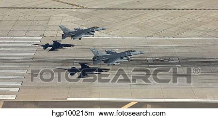 Two F-16's land in formation at Luke Air Force Base, Arizona. View Large Photo Image Picture - Two F-16's land in formation at Luke Air Force Base, Arizona.. Fotosearch
