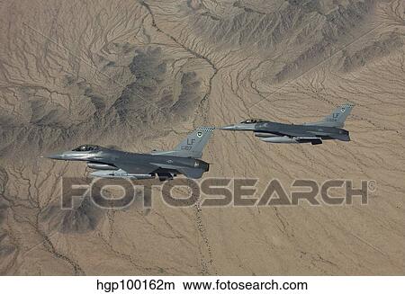 Two F-16's on a training mission over the Arizona desert. View Large Photo Image Picture - Two F-16's on a training mission over the Arizona desert.. Fotosearch