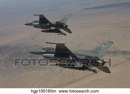 Two F-16's on a training mission over the Arizona desert. View Large Photo Image Picture - Two F-16's on a training mission over the Arizona desert.. Fotosearch
