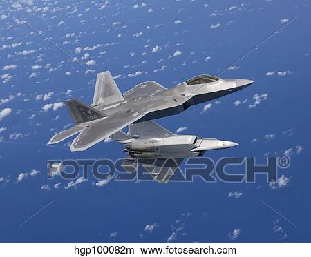 Two F-22 Raptors maneuver while flying a training mission over Japan. View Large Photo Image Picture - Two F-22 Raptors maneuver while flying a training mission over Japan.. Fotosearch