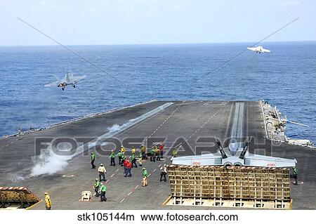 Two F/A-18 Hornets take off from the aircraft carrier USS Ronald Reagan. View Large Photo Image Picture - Two F/A-18 Hornets take off from the aircraft carrier USS Ronald Reagan.. Fotosearch
