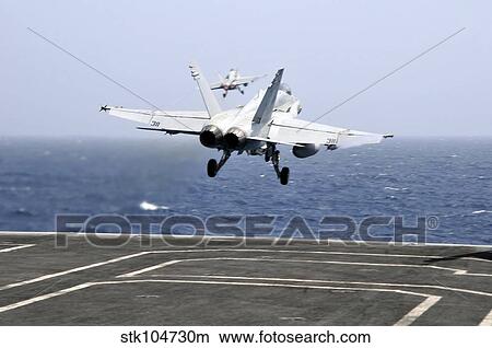 Two F/A-18C Hornet strike fighters launch from the aircraft carrier USS Ronald Reagan. View Large Photo Image Picture - Two F/A-18C Hornet strike fighters launch from the aircraft carrier USS Ronald Reagan.. Fotosearch