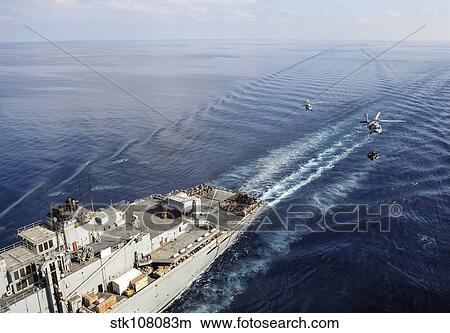 Two MH-60S Sea Hawk helicopters transport supplies to ships. View Large Photo Image Picture - Two MH-60S Sea Hawk helicopters transport supplies to ships.. Fotosearch