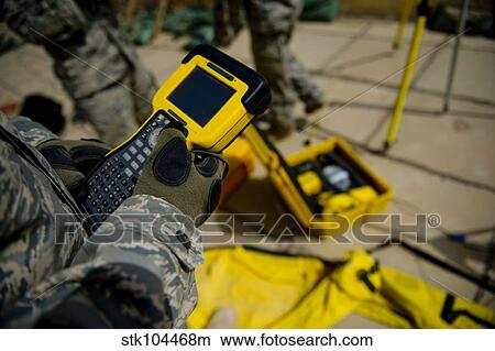 Picture - U. S. Air Force Airman uses a satellite base station to collect data on terrain features and distances.. Fotosearch