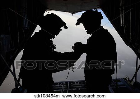 Picture - U. S. Air Force loadmasters fold the American flag aboard an HC-130 Hercules.. Fotosearch