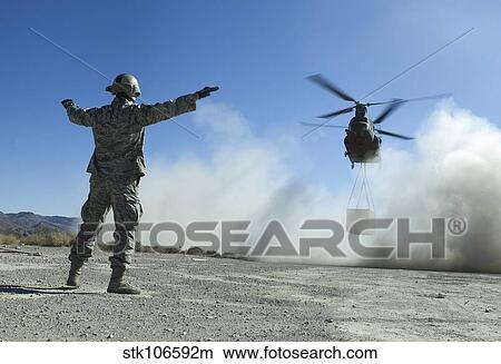U. S. Air Force Master Sergeant guides a CH-47 Chinook to a drop site. View Large Photo Image Picture - U. S. Air Force Master Sergeant guides a CH-47 Chinook to a drop site.. Fotosearch