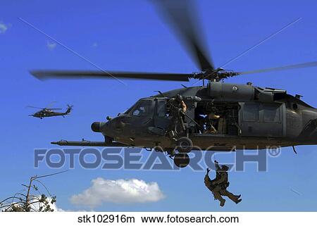 U. S. Air Force Pararescuemen are hoisted into an HH-60 Pavehawk helicopter. View Large Photo Image Picture - U. S. Air Force Pararescuemen are hoisted into an HH-60 Pavehawk helicopter.. Fotosearch