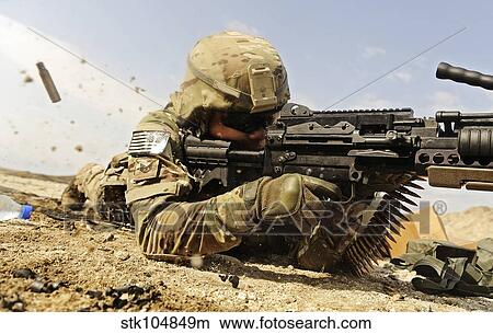Picture - U. S. Air Force soldier fires the Mk48 super SAW machine gun.. Fotosearch