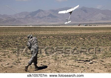Picture - U. S. Army soldier launches an RQ-11 Raven unmanned aerial vehicle.. Fotosearch