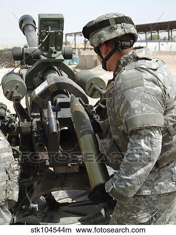 U. S. Army Soldier loads a 105mm artillery round into a M119 Howitzer. View Large Photo Image Picture - U. S. Army Soldier loads a 105mm artillery round into a M119 Howitzer.. Fotosearch