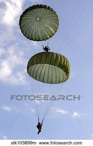 U. S. Army Soldiers parachute down after jumping from a C-130 Hercules. View Large Photo Image Picture - U. S. Army Soldiers parachute down after jumping from a C-130 Hercules.. Fotosearch