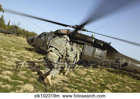 U. S. Army Soldiers prepare to board a UH-60 Black Hawk helicopter. View Large Photo Image Picture - U. S. Army Soldiers prepare to board a UH-60 Black Hawk helicopter.. Fotosearch